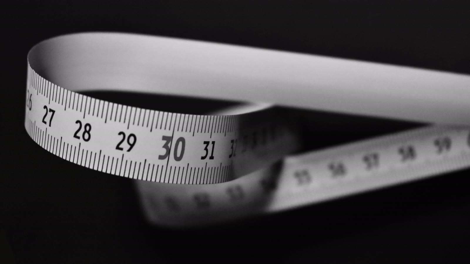 Et målebånd i centimeter rullet ud på en mørk baggrund